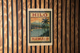 A vintage-style stamp or sign with the text "HILO" and "HAWAII 18¢" displayed on a wooden wall.