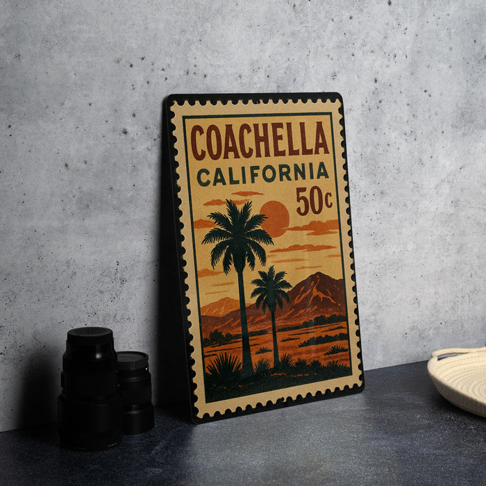 A vintage-style stamp depicting a palm tree and sunset, with the text "COACHELLA CALIFORNIA 50¢" printed on it.