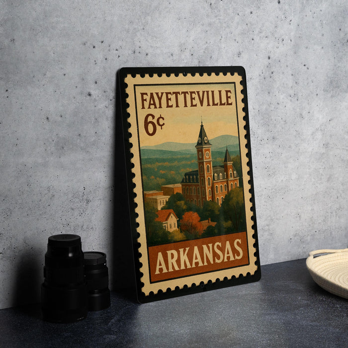 A framed vintage postage stamp from Fayetteville, Arkansas, featuring an illustration of a building and a clock tower.
