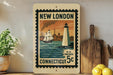 A vintage postage stamp from New London, Connecticut, featuring a lighthouse and a ship on the water, displayed on a shelf next to a wooden cutting board and some lemons.