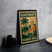 A metal sign with a tropical cityscape and palm trees, featuring the text "GUAYNABO PUERTO RICO" on it, is displayed on a table.