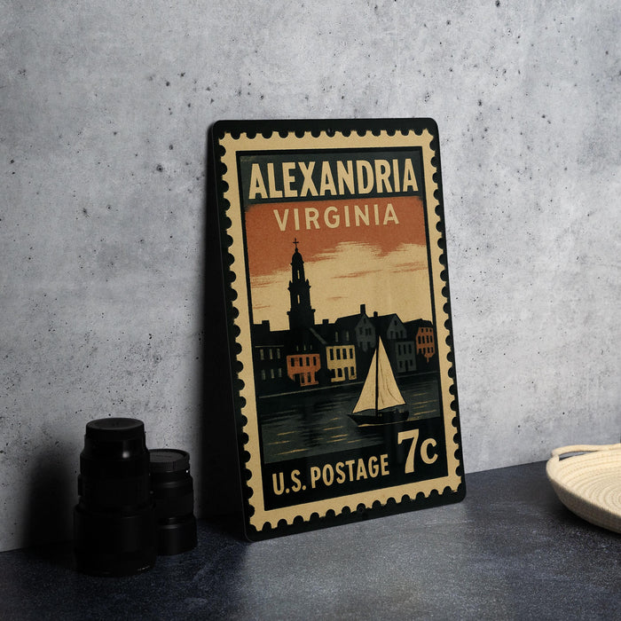 A vintage-style postage stamp from the United States, featuring an illustration of a cityscape with a sailboat, placed on a countertop next to some black camera lenses.