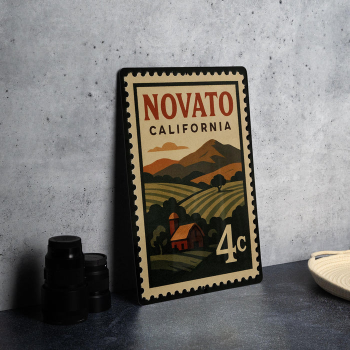 A vintage-style metal stamp with the text "NOVATO CALIFORNIA" and an illustration of a rural landscape with a house and farm.