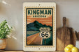 A framed poster of Route 66 in Arizona hangs on a wall, featuring a mountain landscape and the iconic Route 66 sign.