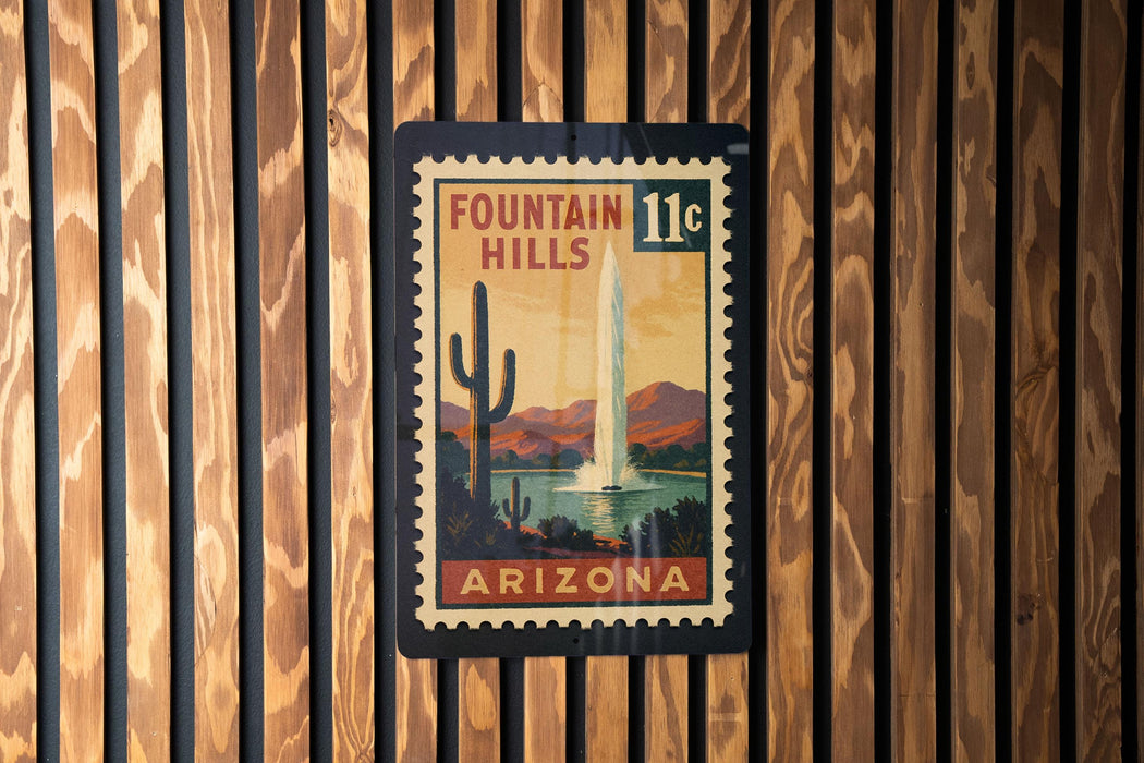 A vintage postage stamp from Arizona featuring a fountain in the background, mounted on a wooden wall.