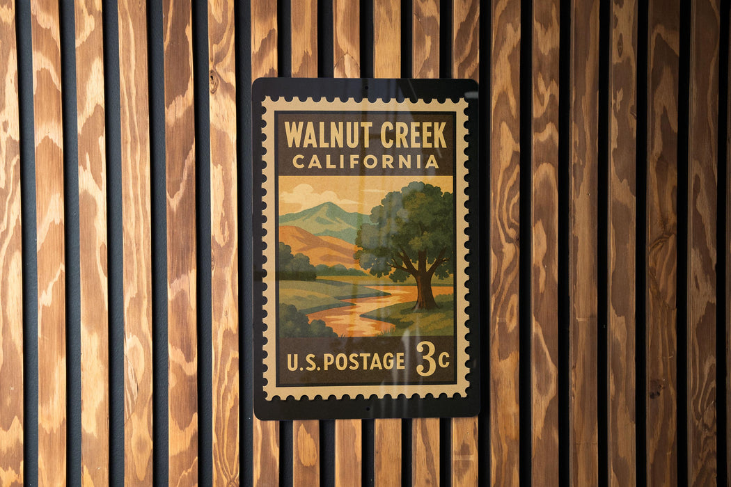 A vintage-style postage stamp for Walnut Creek, California, with a landscape scene on it, is displayed on a wooden wall.