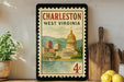 A framed vintage postage stamp depicting the Charleston, West Virginia capitol building, with a cityscape and water in the background.