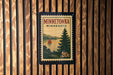 A Minnesota postage stamp with a scenic landscape of a lake and pine trees, mounted on a wooden wall.