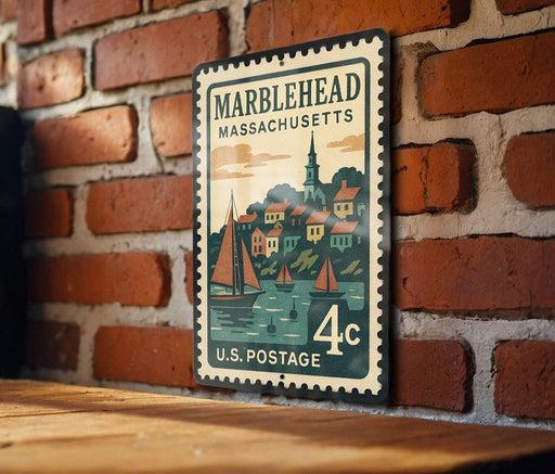 A vintage-style postage stamp from Marblehead, Massachusetts, featuring a colorful illustration of a town with a river and sailboats.