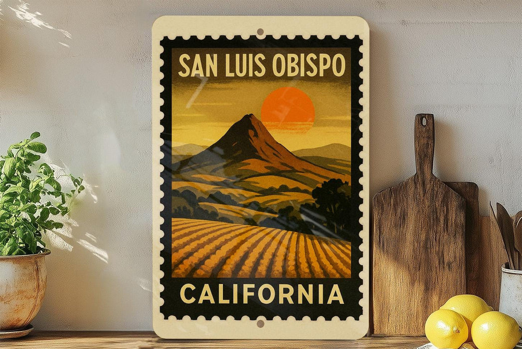 A framed vintage-style poster of San Luis Obispo, California, featuring a mountain landscape with a sunset in the background.