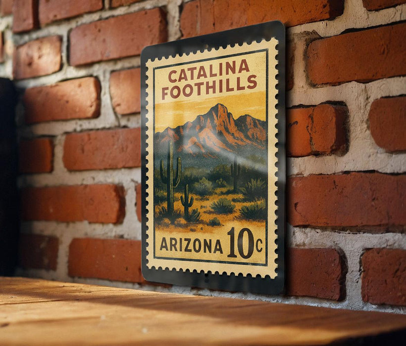 A metal sign with a desert landscape and mountains, mounted on a brick wall.