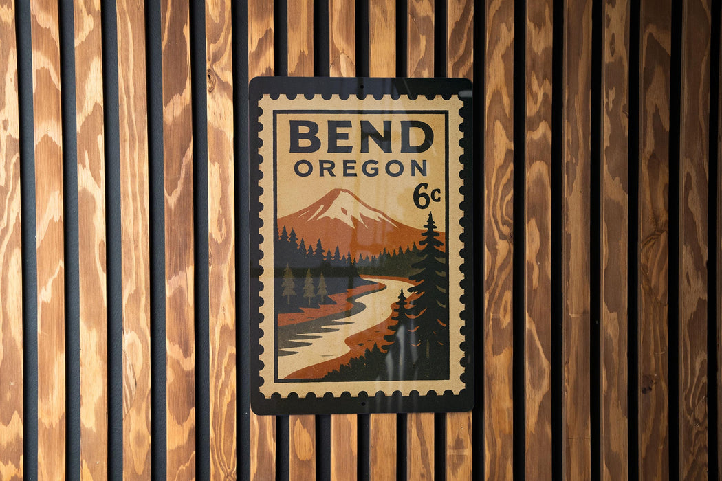 A Bend Oregon postage stamp is displayed on a wooden wall.