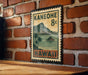 A vintage-style metal sign with a tropical island and palm trees, mounted on a brick wall.