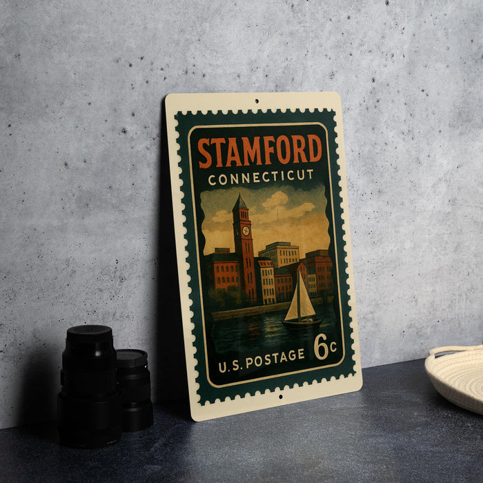 A vintage postage stamp from Connecticut, featuring a cityscape and a sailboat, is displayed on a table.
