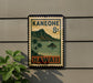 A vintage-style sign with the text "Kaneohe 8c" and "Hawaii" printed on it, mounted on a wall next to a plant.