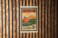 A California postage stamp with an illustration of an orange fruit, likely an apple, on a wooden background.