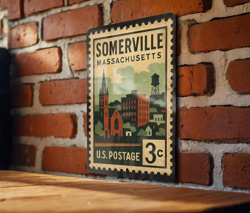 A vintage-style postage stamp from the United States, featuring an illustration of a town and buildings, mounted on a brick wall.