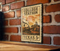 A vintage-style metal sign with a train and a building, mounted on a brick wall.