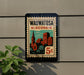 A vintage-style metal sign with the text "Wauwatosa Wisconsin" and an illustration of a cityscape, mounted on a wall.