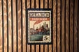 A vintage-style stamp or poster with the text "HAMMOND INDIANA" and an illustration of a cityscape with a bridge and river.