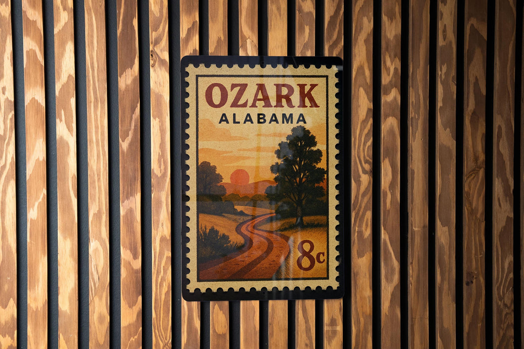 A vintage-style postage stamp from Alabama, featuring a scenic landscape with a winding road and a sunset in the background.