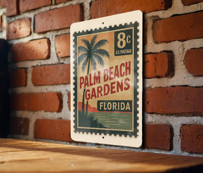 A vintage-style postage stamp featuring a palm tree and the text "Palm Beach Gardens, Florida" is displayed on a brick wall.