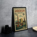 A vintage postage stamp from Indiana, featuring an illustration of a cityscape, is displayed on a countertop next to some black camera lenses.