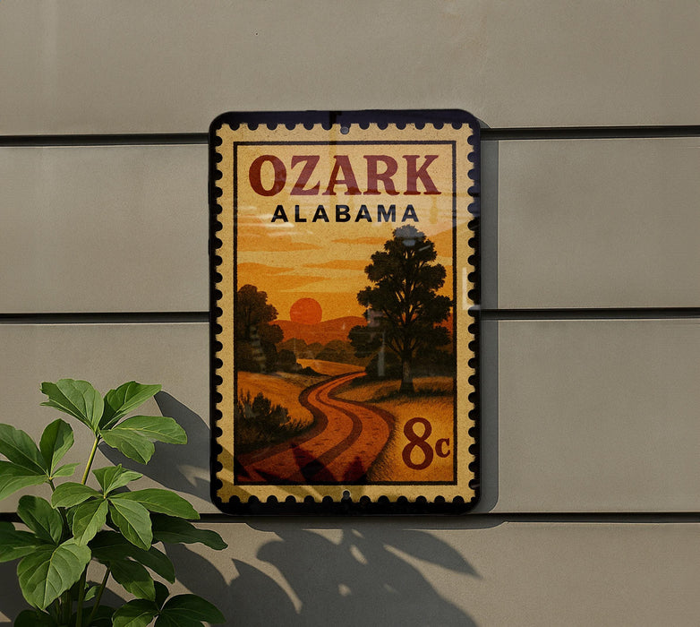 A vintage-style postage stamp from Alabama, featuring a scenic landscape with a winding road and a sunset in the background.