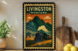 A vintage-style poster of Livingston, Montana, featuring a steam locomotive and mountains in the background, displayed on a wall next to a wooden cutting board and a potted plant.