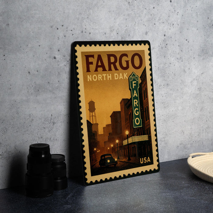 A framed poster of the Fargo, North Dakota theater, featuring a vintage-style illustration of the theater and surrounding buildings.