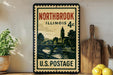 A vintage postage stamp from Illinois 4c, featuring a scenic landscape with a church and a river, displayed on a shelf next to a wooden cutting board and some lemons.