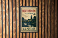 A vintage postage stamp from Illinois, featuring a scenic landscape with a bridge and trees, mounted on a wooden wall.