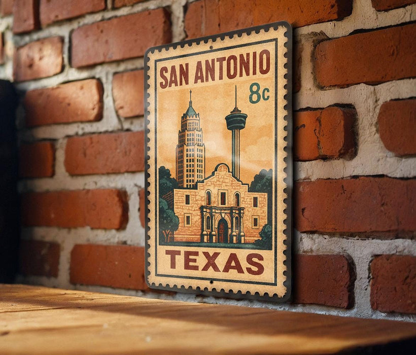 A vintage-style metal sign depicting the San Antonio, Texas skyline, with a building and a tower, mounted on a brick wall.