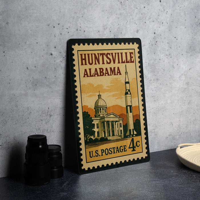 A vintage postage stamp from the United States Postal Service, featuring an illustration of a building and a rocket ship, with the text "HUNTSVILLE ALABAMA" and "U.S. POSTAGE 4c".