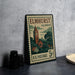 A vintage postage stamp from Illinois, featuring a clock tower and a rural landscape, placed on a table next to some black camera lenses.