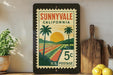 A framed vintage postage stamp from Sunnyvale, California, depicting a tropical landscape with palm trees and a sunset.
