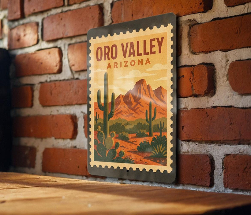 A vintage-style metal sign with a desert landscape and mountains, mounted on a brick wall.