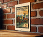 A vintage-style postage stamp from Huntington, West Virginia, featuring a cityscape and a bridge, is displayed on a brick wall.