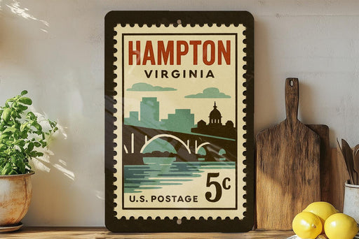 A vintage postage stamp from Hampton, Virginia, featuring a cityscape and a bridge, displayed on a shelf next to a wooden cutting board and some lemons.
