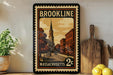 A framed vintage postage stamp from Massachusetts, featuring an illustration of a church and a street scene, is displayed on a shelf next to a wooden cutting board and some lemons.