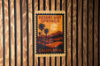 A poster of Desert Hot Springs, California, featuring palm trees and a sunset landscape, is displayed on a wooden wall.