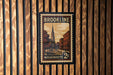A vintage postage stamp from Massachusetts, featuring a church and a street scene, is displayed on a wooden wall.