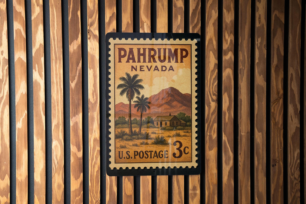 A vintage U.S. postage stamp from Nevada, featuring a desert landscape with palm trees and mountains, mounted on a wooden wall.