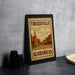 A framed vintage postage stamp depicting Trussville, Alabama, with a church and buildings in the background.