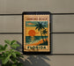 A vintage-style sign for Ormond Beach, Florida, featuring a palm tree and a sunset over the ocean.