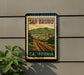 A vintage-style poster of San Bruno, California, featuring a train track and a town in the background, is displayed on a wall.