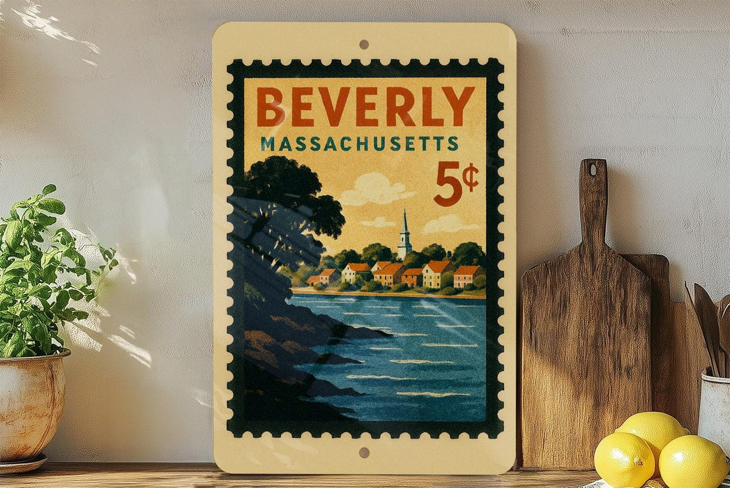 A vintage postage stamp from Beverly, Massachusetts, depicting a scenic coastal town with a church steeple, is displayed on a shelf next to a wooden cutting board and a potted plant.