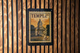 A framed image of a building, likely a historic landmark, is displayed on a wooden wall.