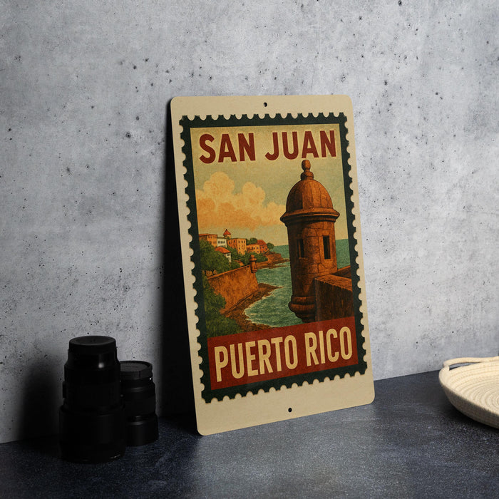 A vintage-style poster of the San Juan, Puerto Rico, featuring a castle and a coastal landscape, is displayed on a wall.