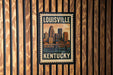 A framed postcard or stamp featuring the skyline of Louisville, Kentucky, with the text "LOUISVILLE 20¢ KENTUCKY" prominently displayed.
